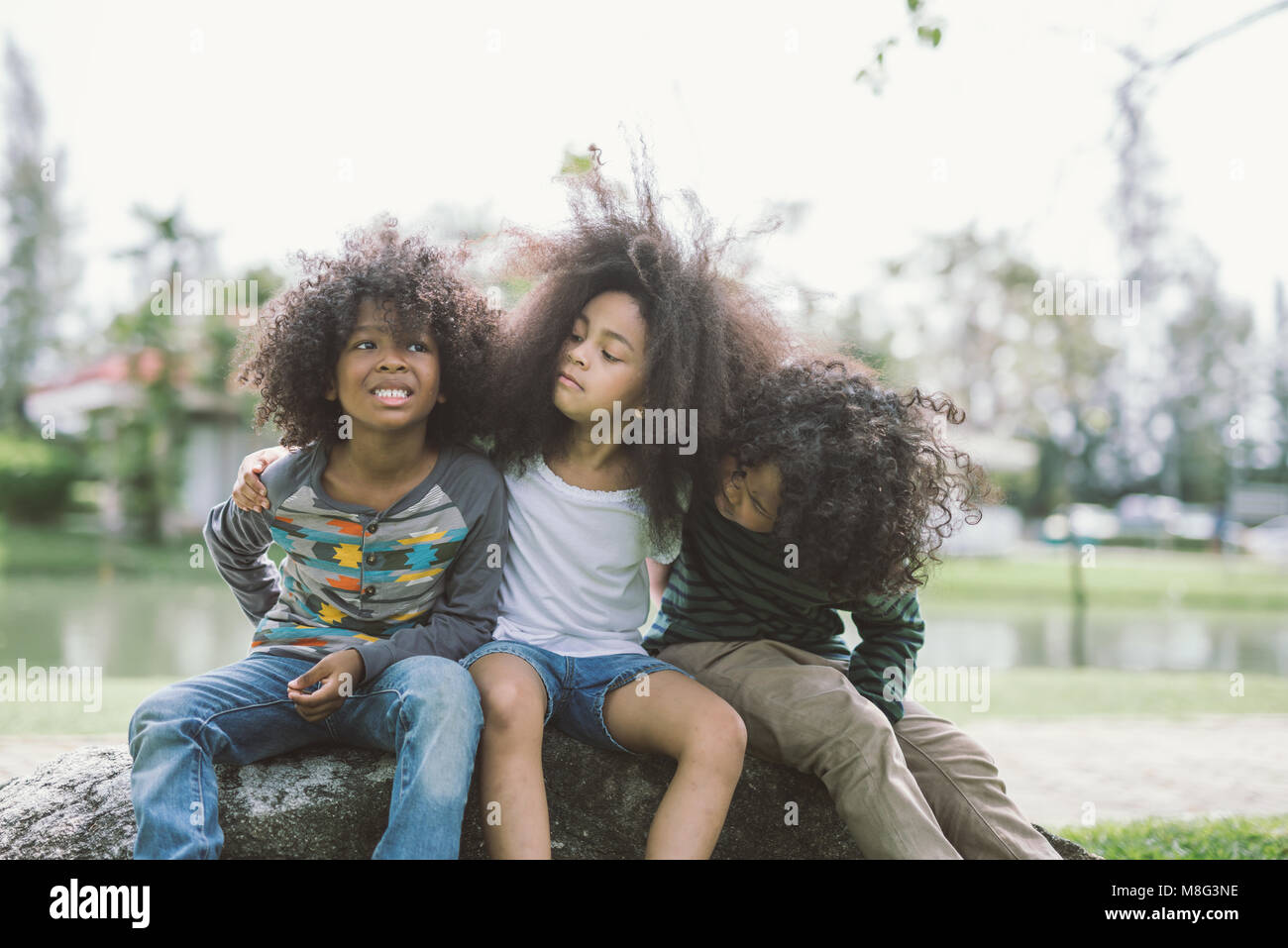 Kinder Freundschaft miteinander Lächeln Glück Konzept. Cute afrikanische amerikanische kleine Jungen und Mädchen umarmen sich in park Stockfoto