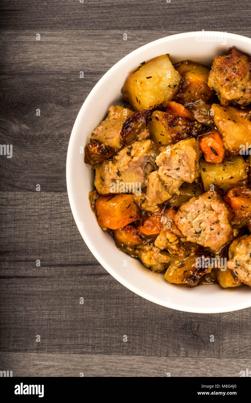 Britische oder Englischen Stil langsam geröstet zog Schweinefleisch und Füllung Kasserolle gegen einen dunklen Küche Tisch Stockfoto