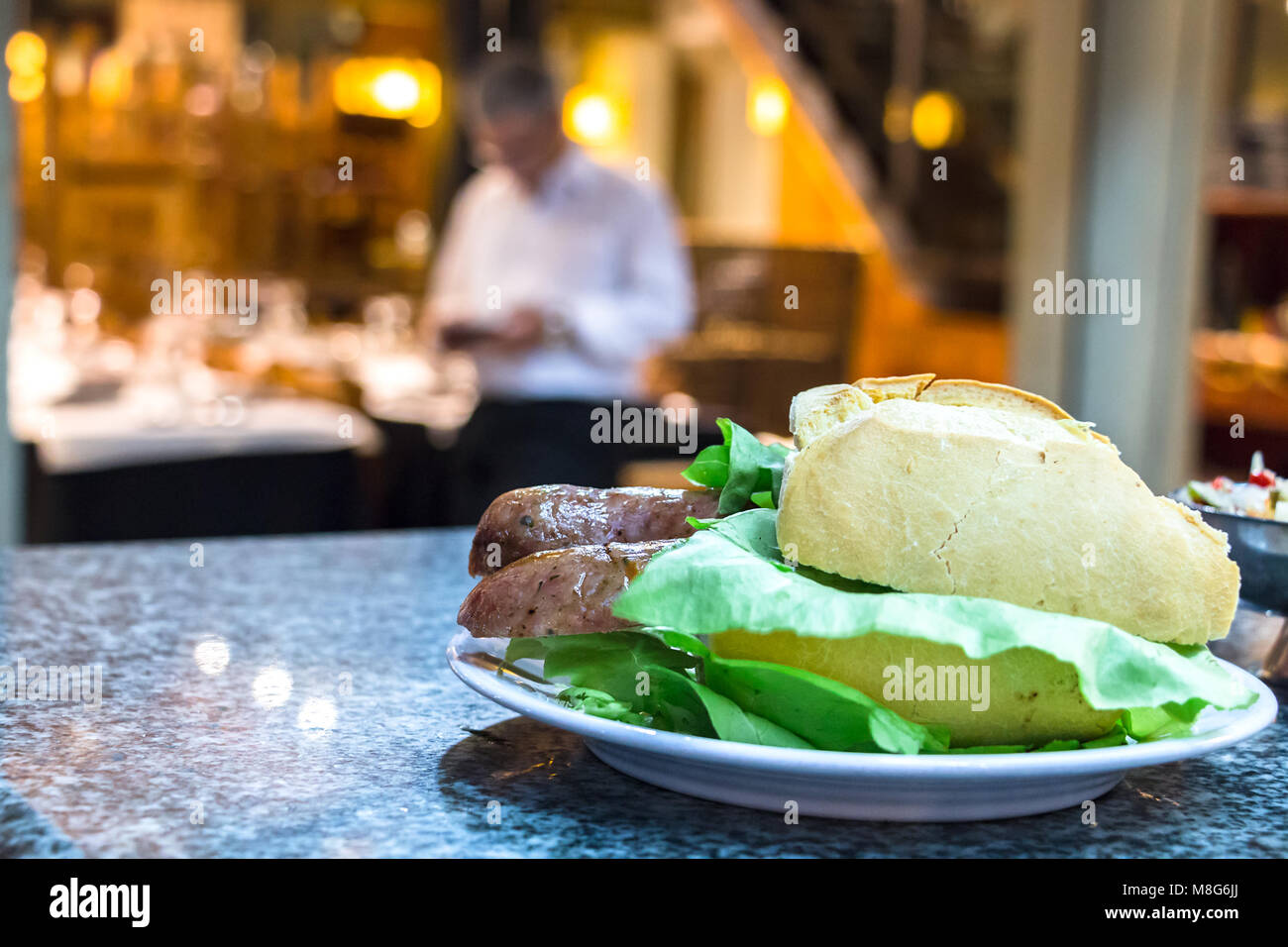 Eine choripan Sandwich mit Salat und französischen weißes Brot auf einem Zähler zum Mercado del Puerto, Montevideo, Uruguay. Stockfoto