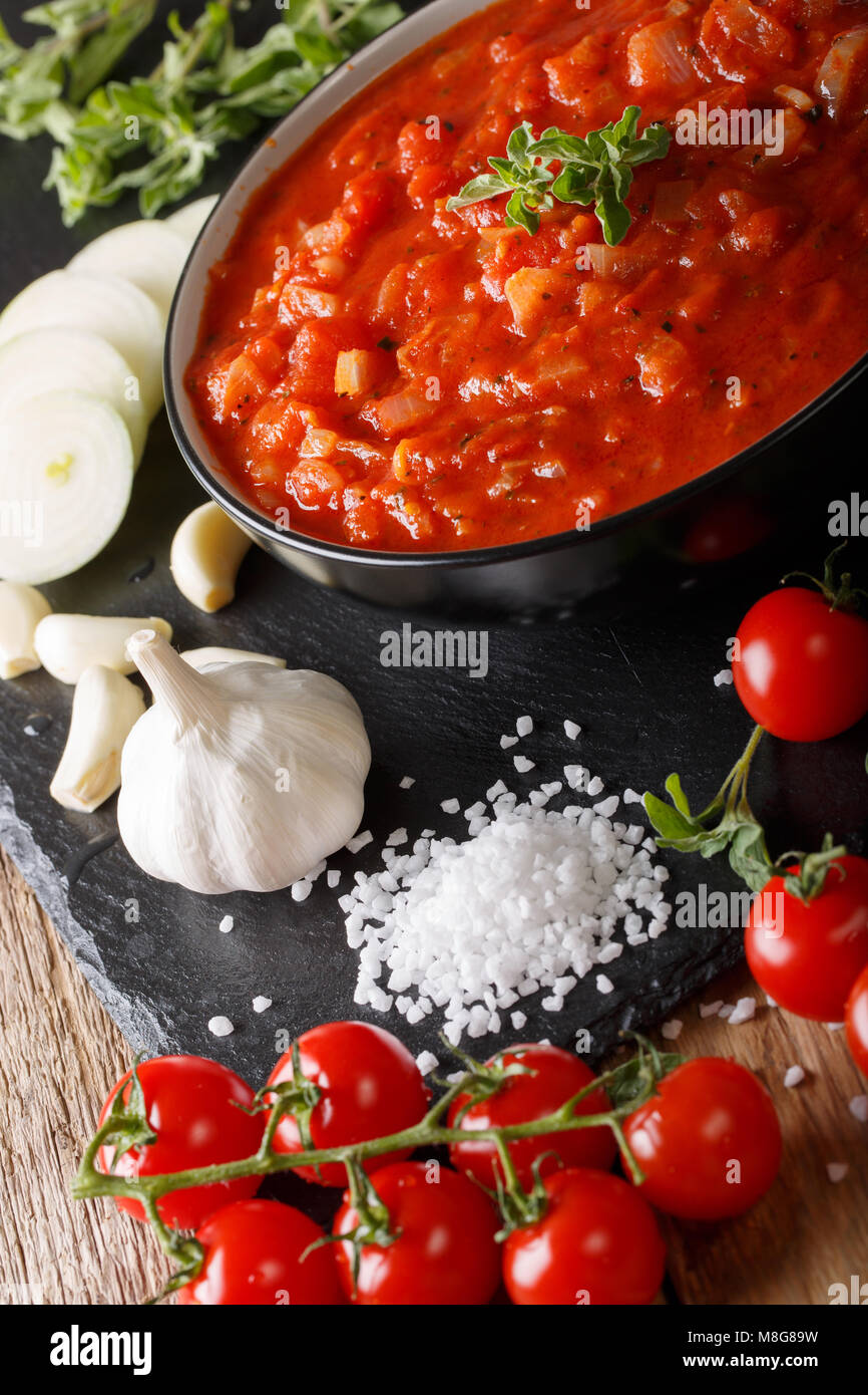 Italienische Tomatensauce pizzaiola mit Zutaten Makro auf dem Tisch. Vertikale Stockfoto