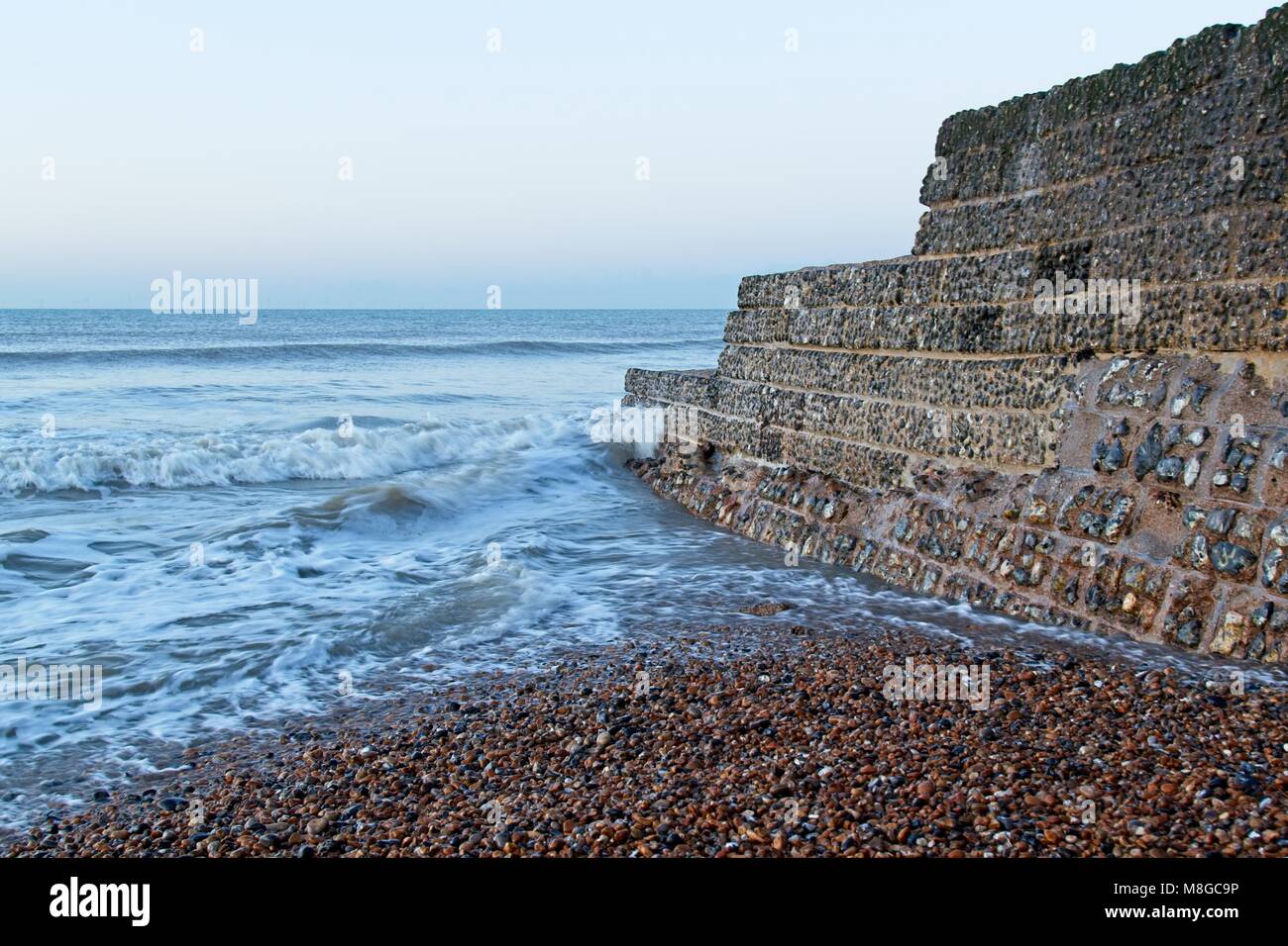 Stein groyne mit Kiesstrand und Surfen am Brighton UK Stockfoto
