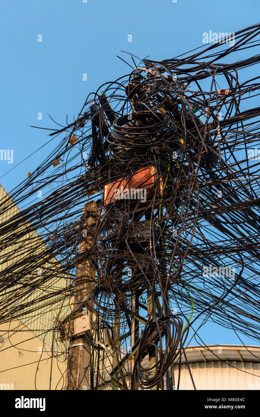 Strommast mit Dutzenden von gefährlichen ungepflegt unordentlich Kabel und Leitungen Stockfoto