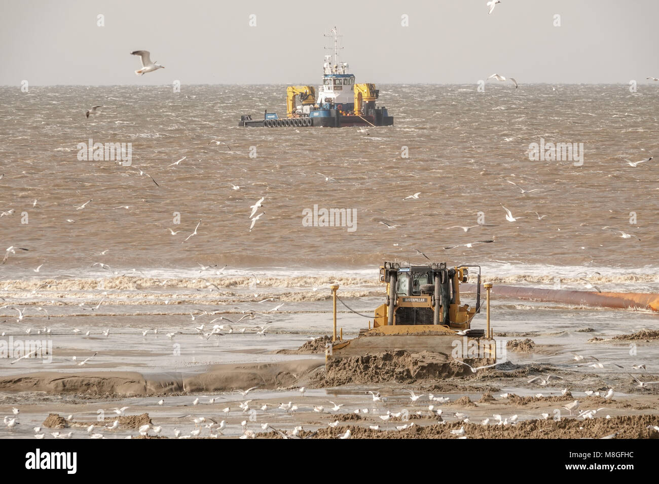 Pumpen Sand auf den Strand zu ersetzen, was aufgrund des steigenden Meeresspiegels verloren gegangen ist. Stockfoto