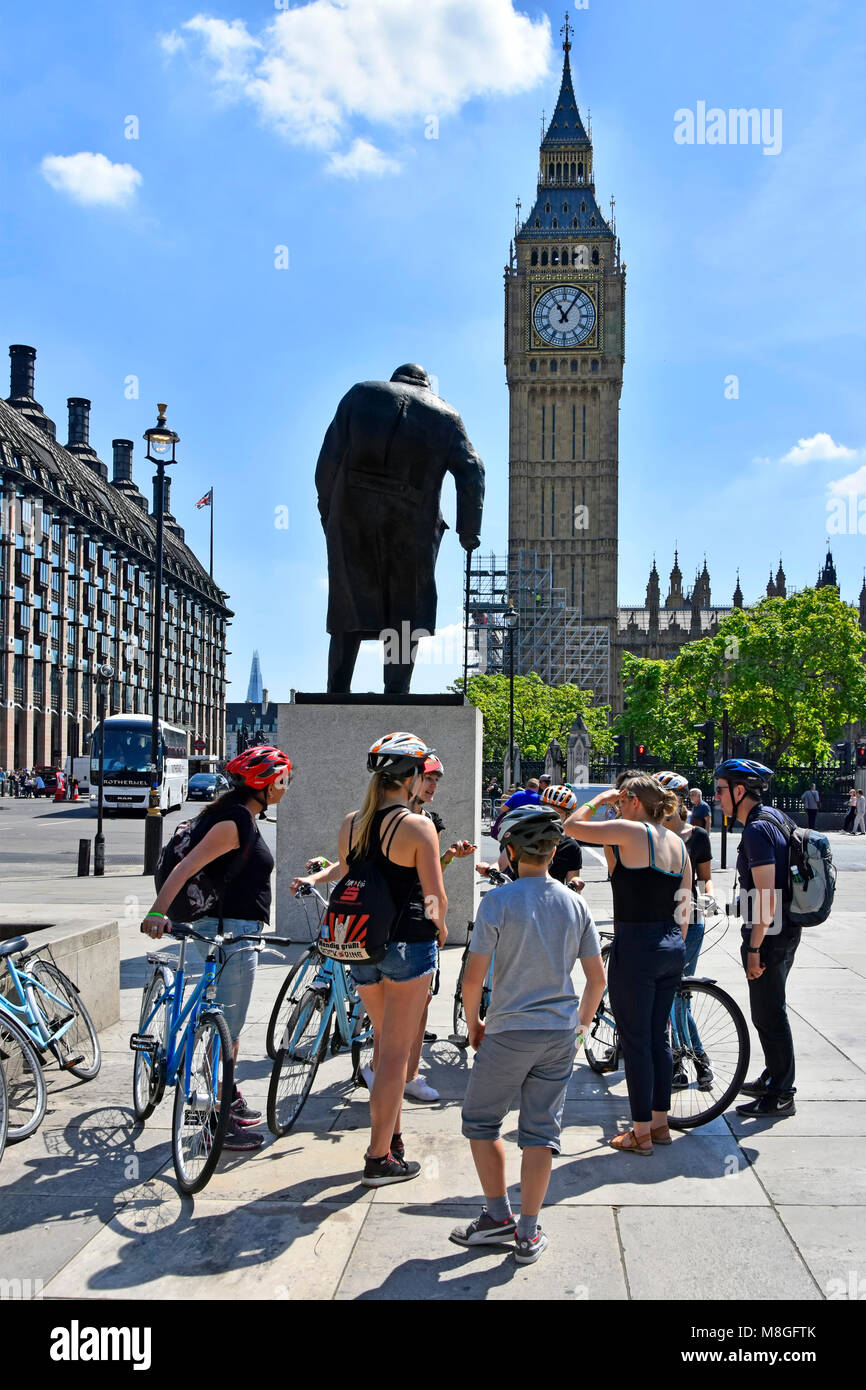 Gruppe von Radtouristen & Tour Guide neben Fahrrad um Statue von Sir Winston Churchill in Parliament Square Big Ben London England Großbritannien gesammelt Stockfoto