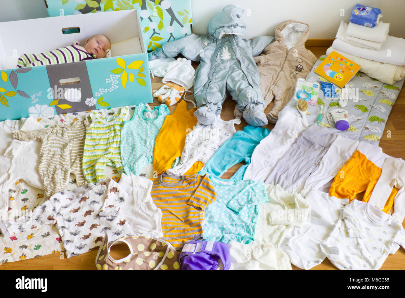 Finnische baby box Inhalt und ein Baby im Baby Box Stockfoto