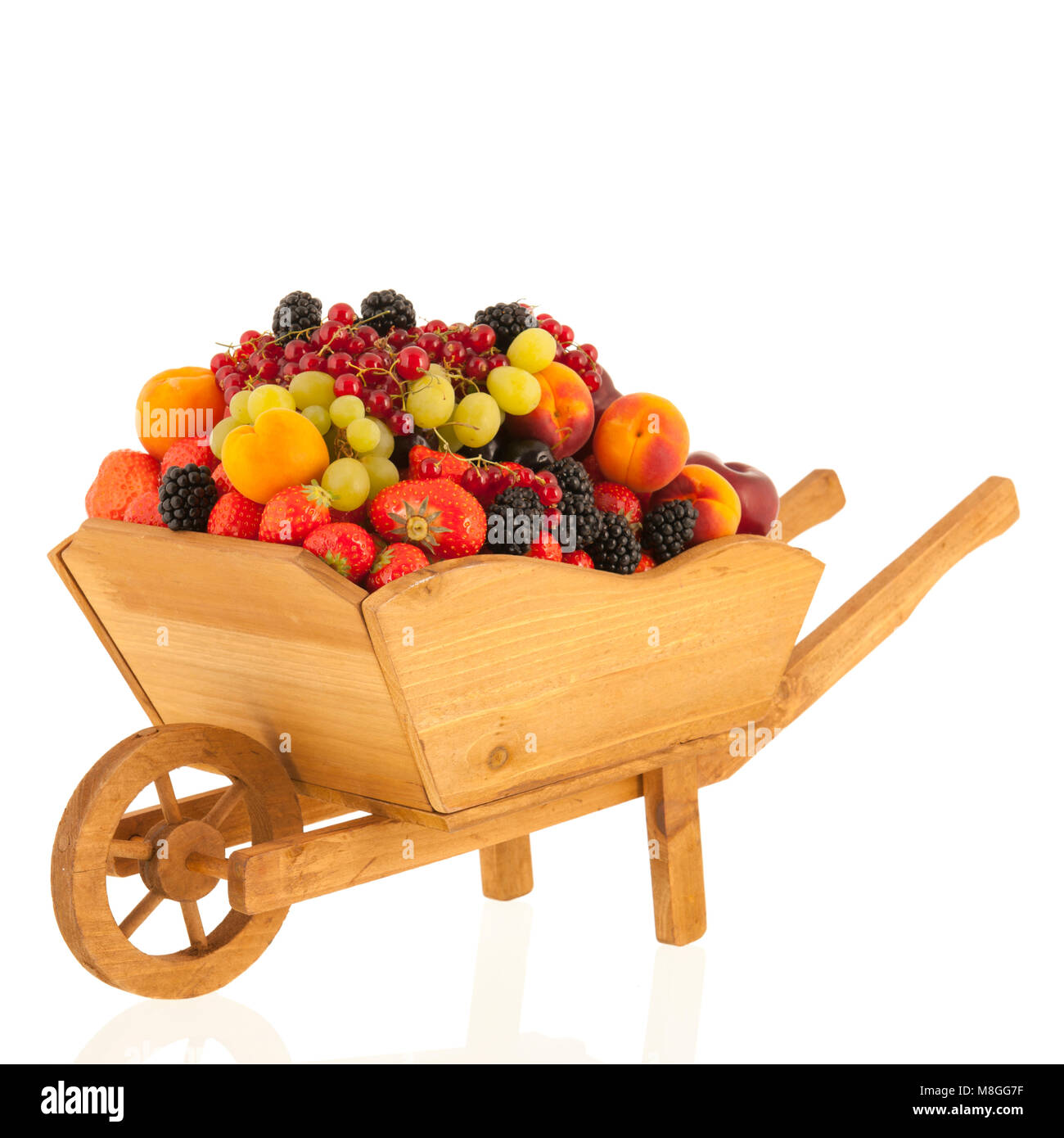 Holz- wheel Barrow mit frischem Sommer Obst auf weißem Hintergrund Stockfoto