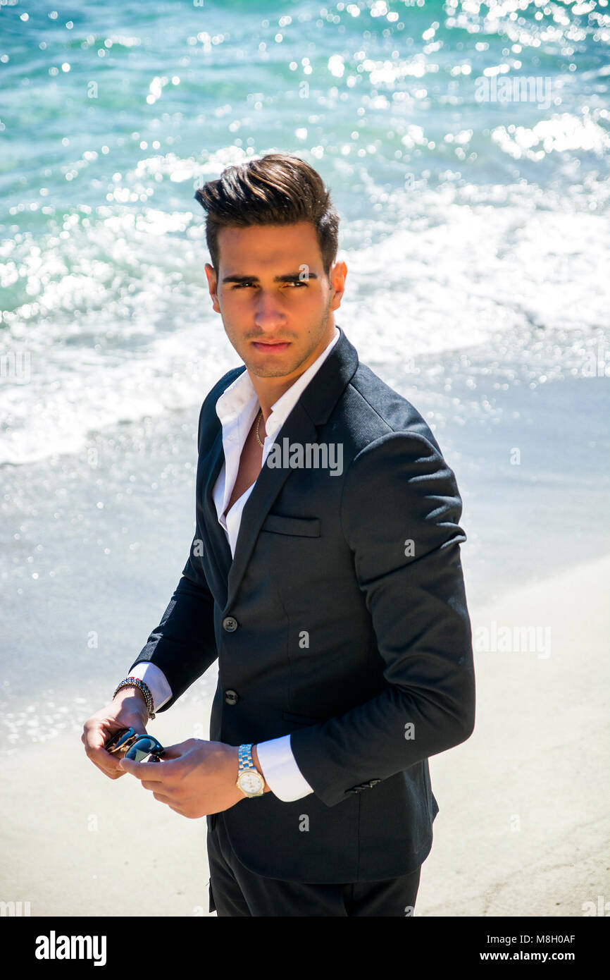 Schöner Mann im klassischen Anzug auf Strand Stockfoto