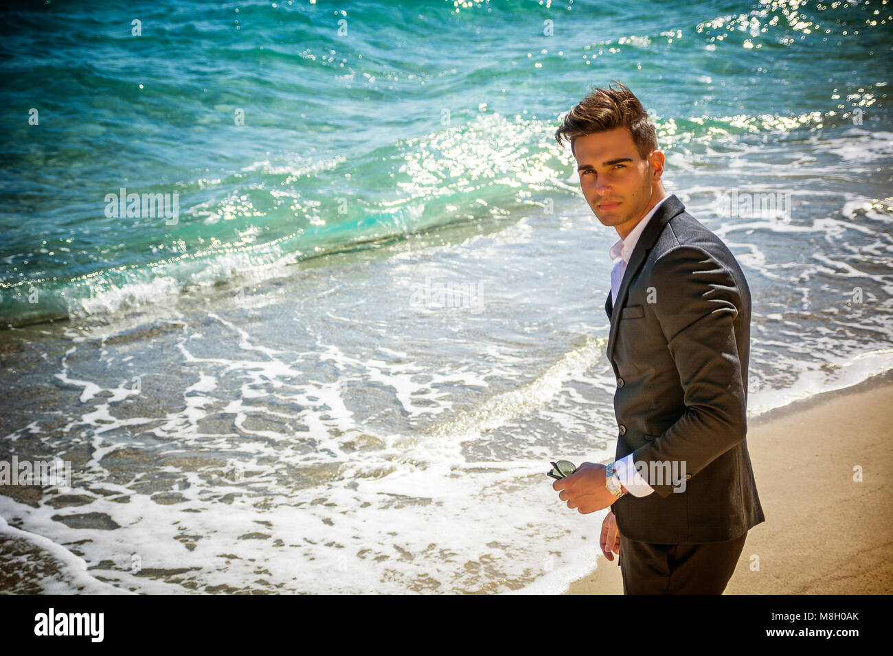 Schöner Mann im klassischen Anzug auf Strand Stockfoto
