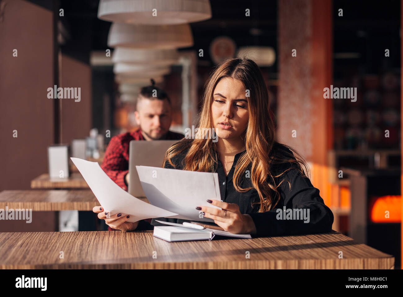 Nachdenklich Geschäftsfrau Dokumente in einem Cafe Stockfoto