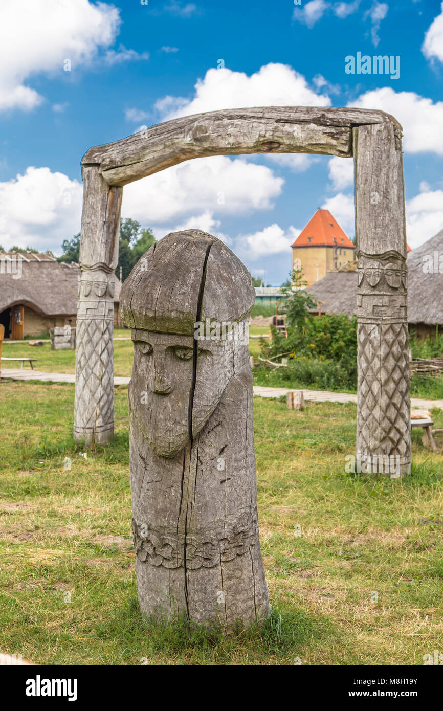 Holz- Idol auf dem Hintergrund der blauen Himmel mit Wolken im ethnischen Dorf. Volen. Polen Stockfoto