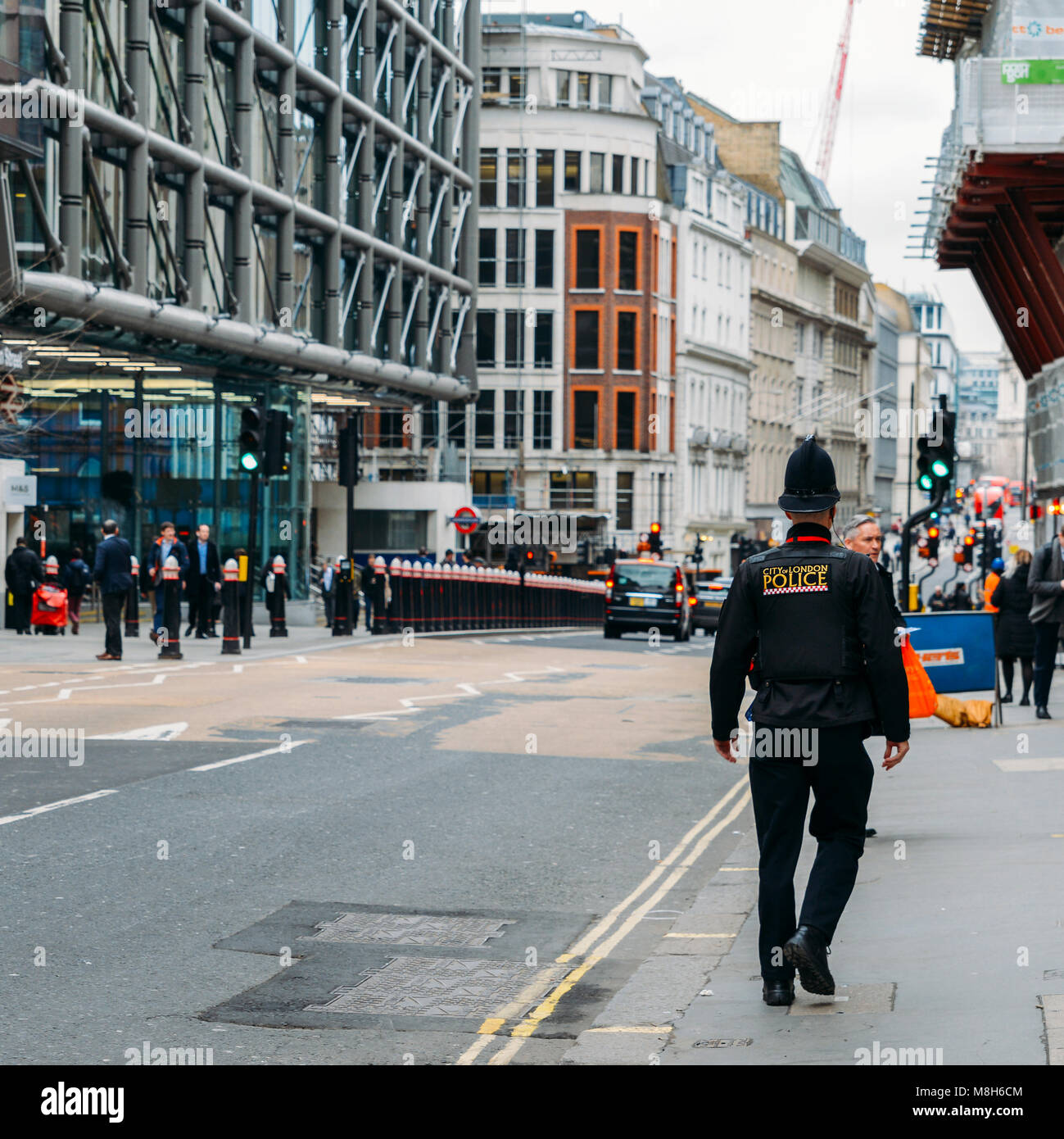 Selektiver Fokus auf der Londoner City Polizeioffizier mit Cannon Street U-Bahnstation im Hintergrund Stockfoto