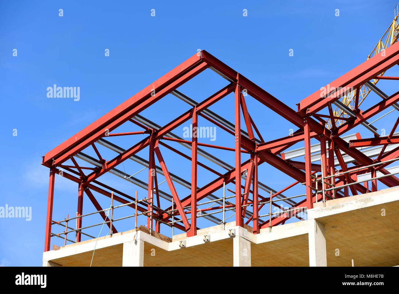 Bauarbeiten sind im Gange. Roter Grundierung lackiertes Stahlwerk. Gerollte Stahlträger rsj-Rahmen. Blauer Himmel Stockfoto