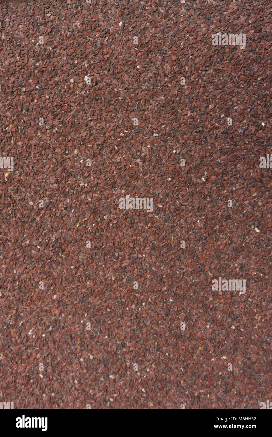 Red Stone Krümel hintergrundstreuung unter der Presse. Stockfoto