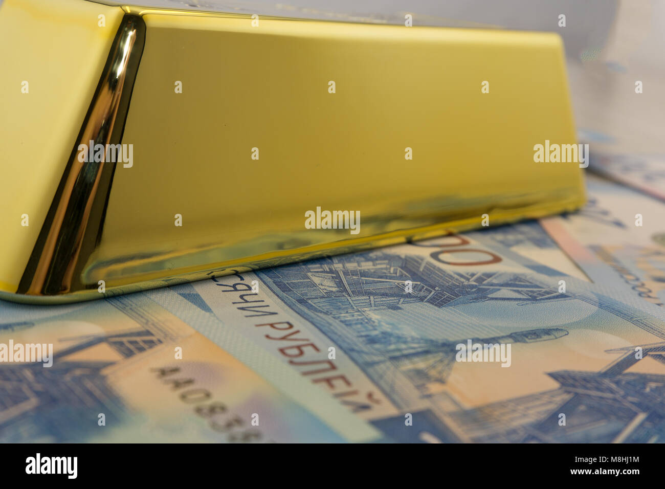 drei große Goldbarren bei vielen Dollarnoten Stockfoto
