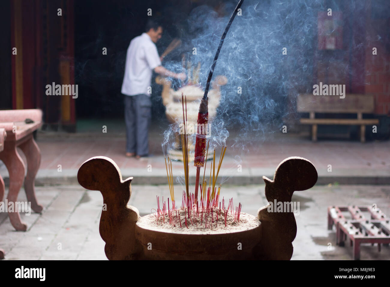 Hoi An, Vietnam - Juni 2017: Mann Räucherstäbchen in der chinesischen Tempel, Hoi An, Vietnam. Stockfoto