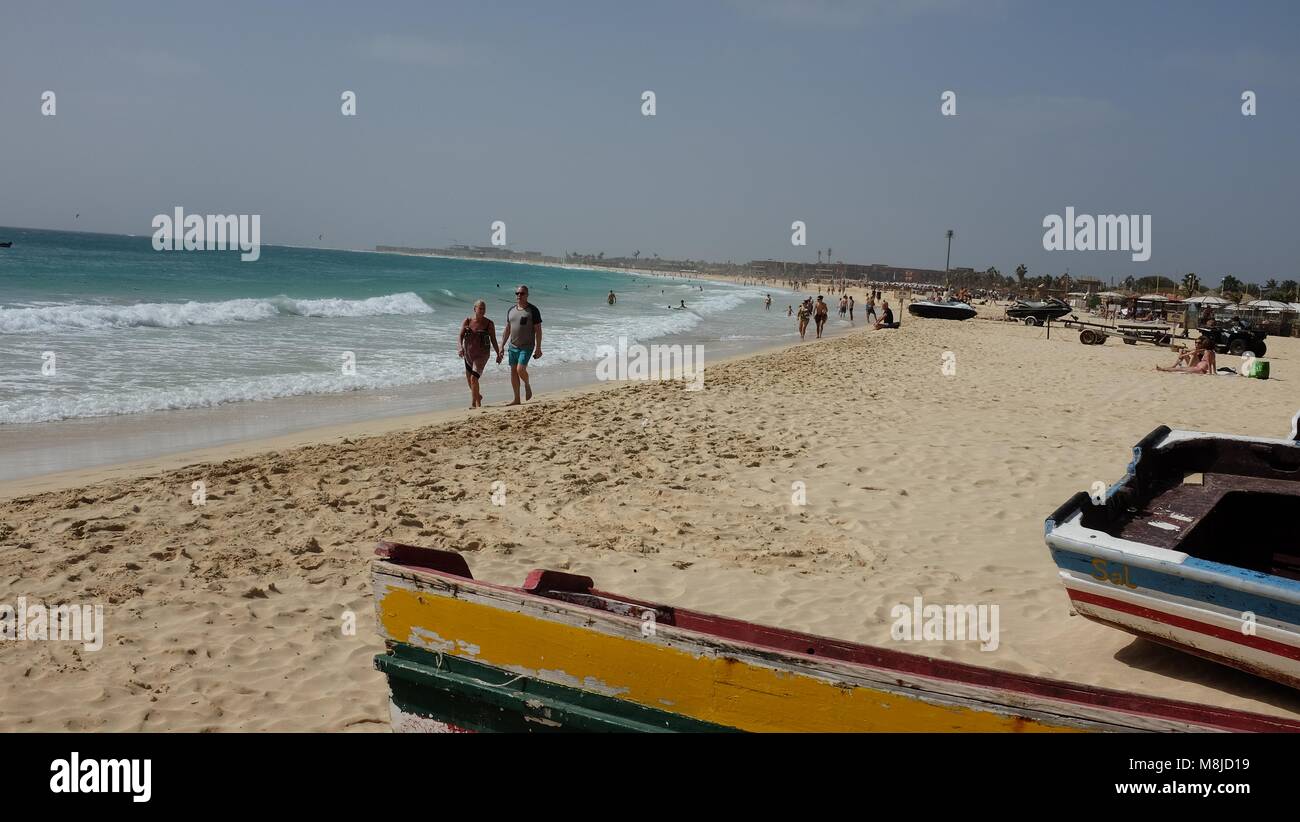 Strand an einem sonnigen Tag, in Santa Maria, Insel Sal, Kap Verde, einschließlich bunte Boote, Sand, Meer, blauer Himmel und Menschen. Stockfoto
