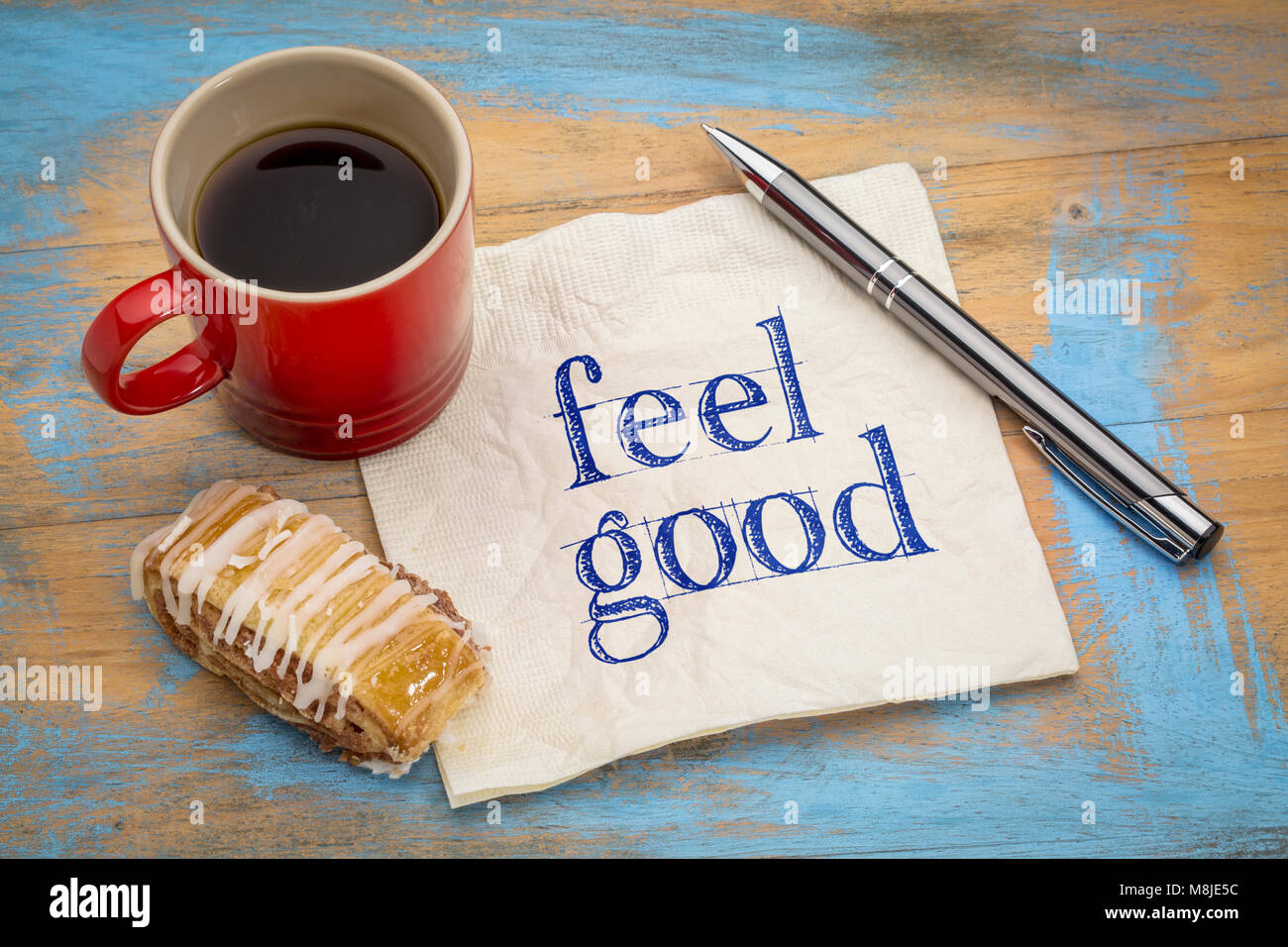 Ein gutes Gefühl - Handschrift auf eine Serviette mit einer Tasse Kaffee und Cookies Stockfoto