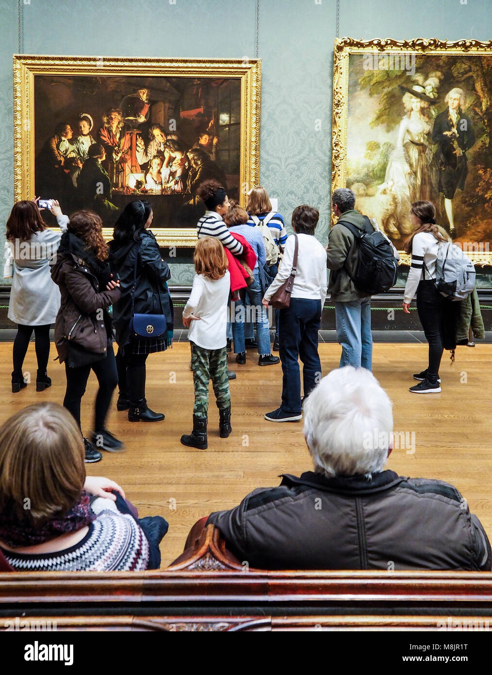 London, Großbritannien - 1 May 2017: Besucher des Londoner National Gallery beobachten den berühmten Gemälden von britischen Künstlern im Museum Sackler Zimmer. Stockfoto