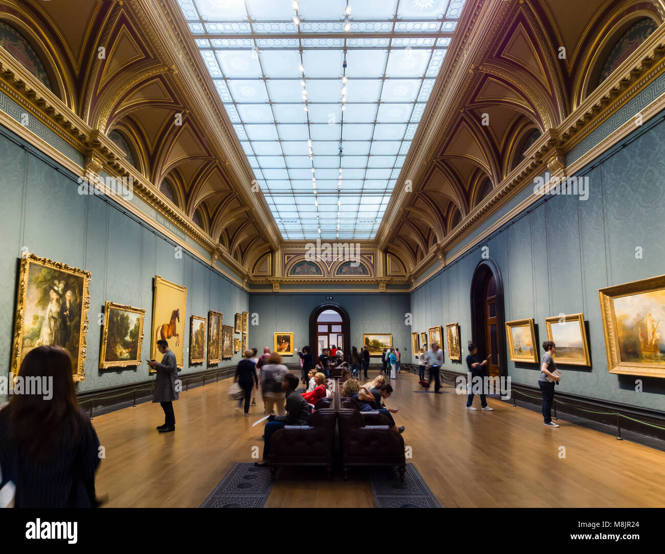 London, Großbritannien - 1 May 2017: Besucher des Londoner National Gallery beobachten den berühmten Gemälden von britischen Künstlern im Museum Sackler Zimmer. Stockfoto