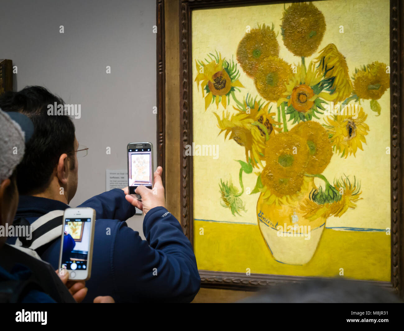 London, Großbritannien - 30 Dez 2017: Besucher der Londoner National Gallery werden über ihre Smartphones Bilder von Vincent van Gogh's Öl Malerei unflowers', eines der bekanntesten Exponate des Museums. Stockfoto