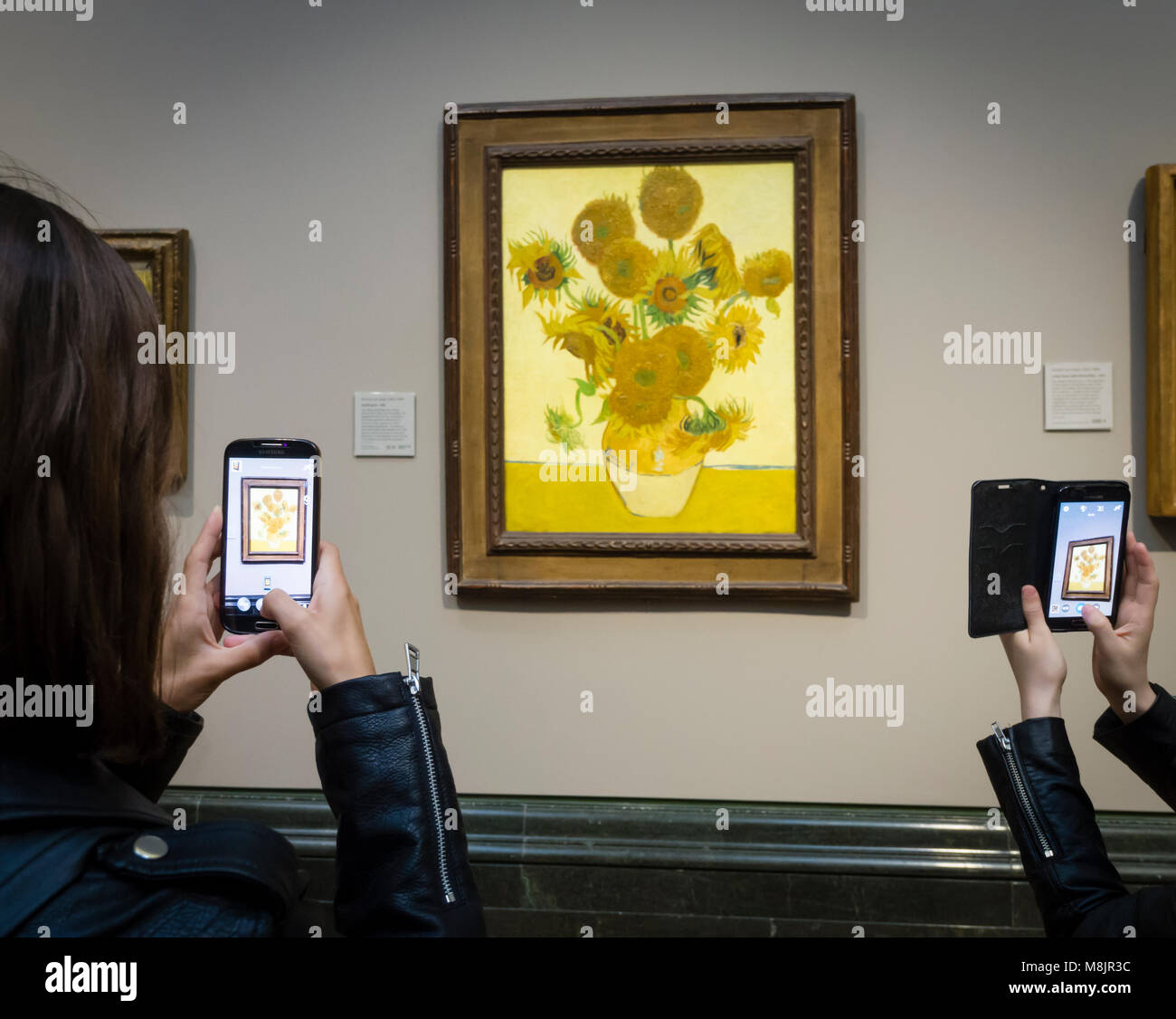 London, Großbritannien - 1 May 2017: Besucher der Londoner National Gallery werden über ihre Smartphones Bilder von Vincent van Gogh's Öl Malerei unflowers', eines der bekanntesten Exponate des Museums. Stockfoto