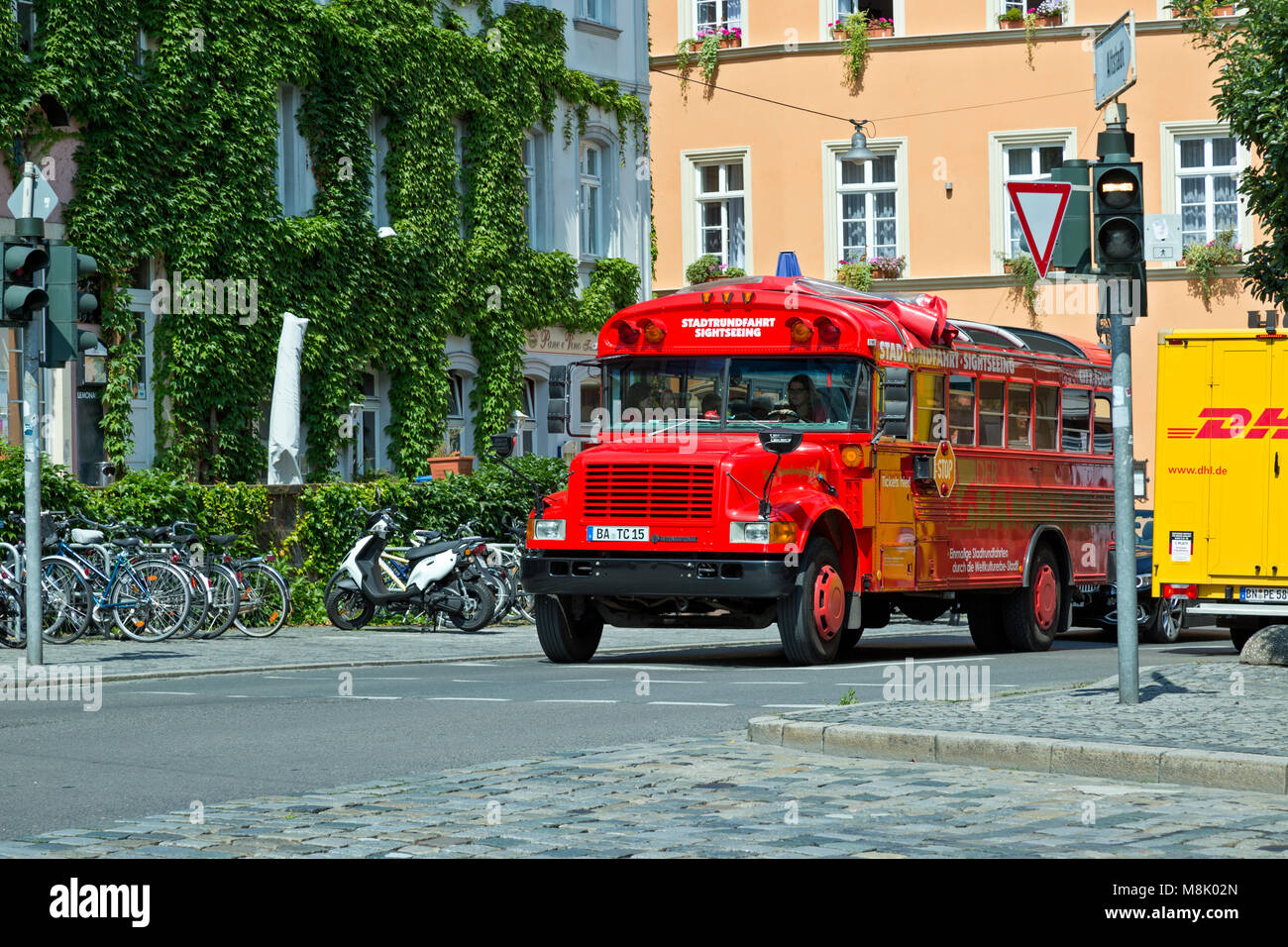 Red Tour Bus an einer Kreuzung in der deutschen Stadt Bamberg. Stockfoto