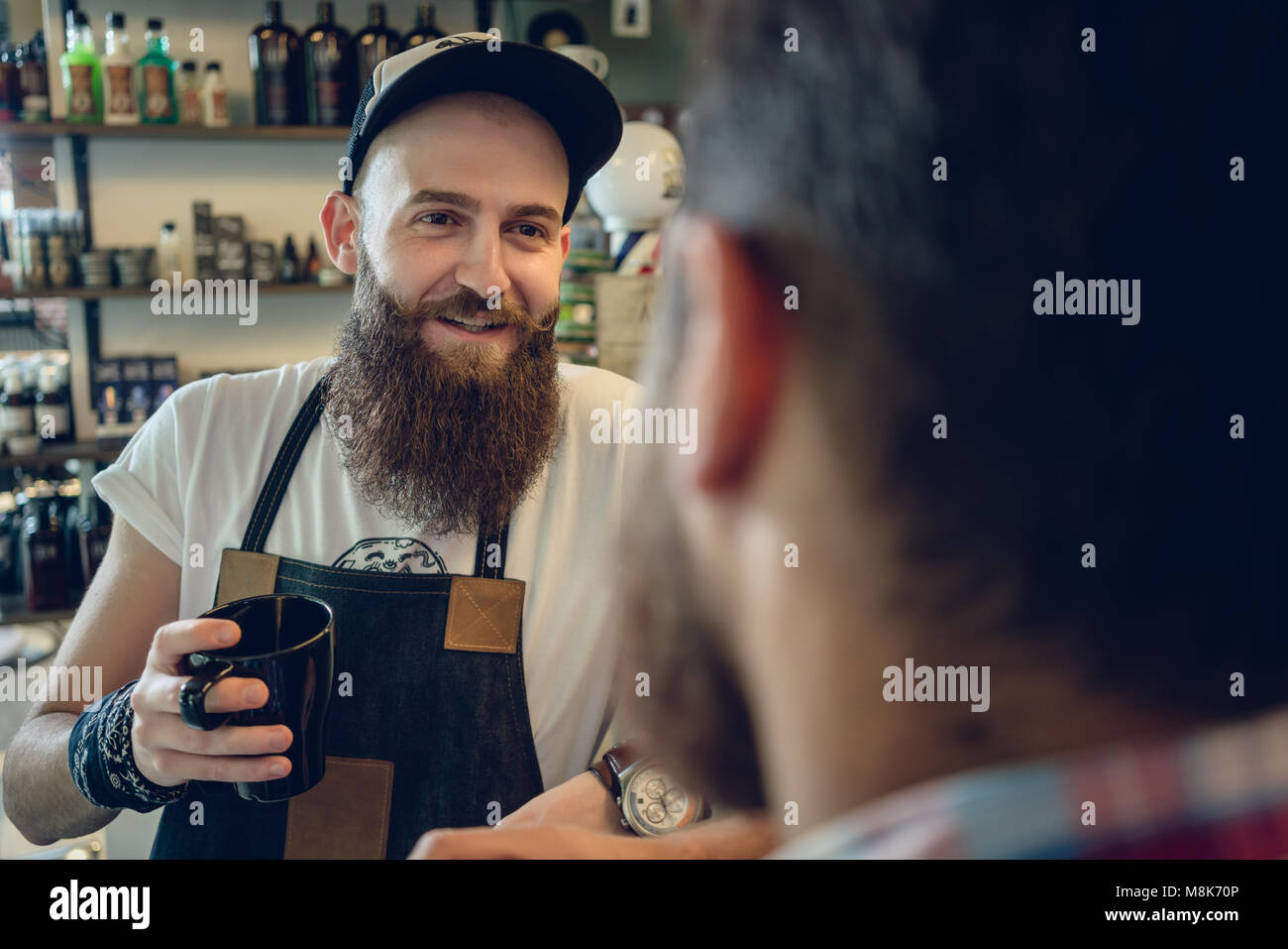 Dedizierte hairstylist Kaffee trinken, mit seinem Kunden und Freund Stockfoto