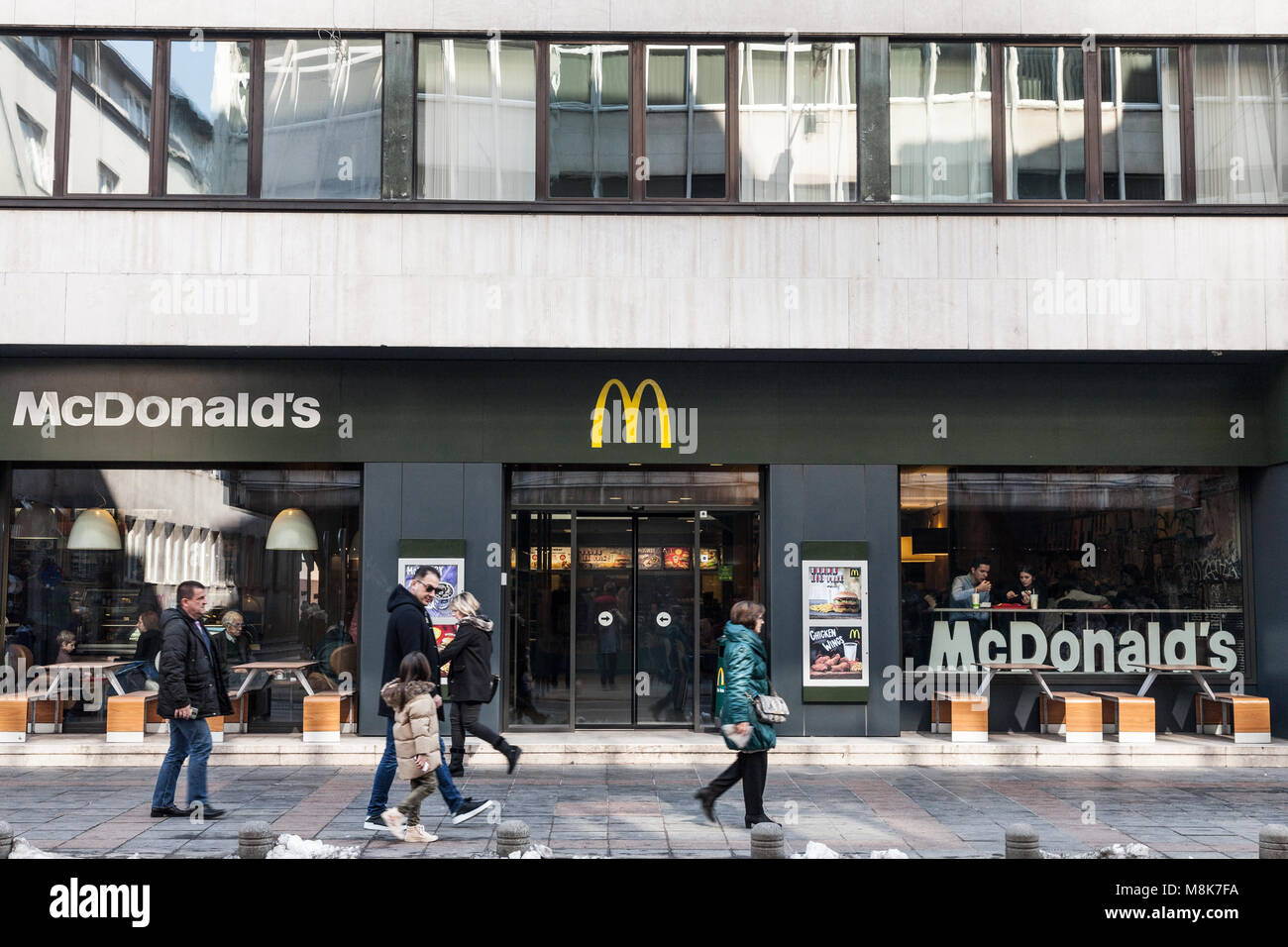 SARAJEVO, BOSNIEN - 17. FEBRUAR 2018: Fußgänger vor einem Mc Donald's Restaurant an der Hauptstraße von Sarajevo. Bosnien ist eine der La Stockfoto