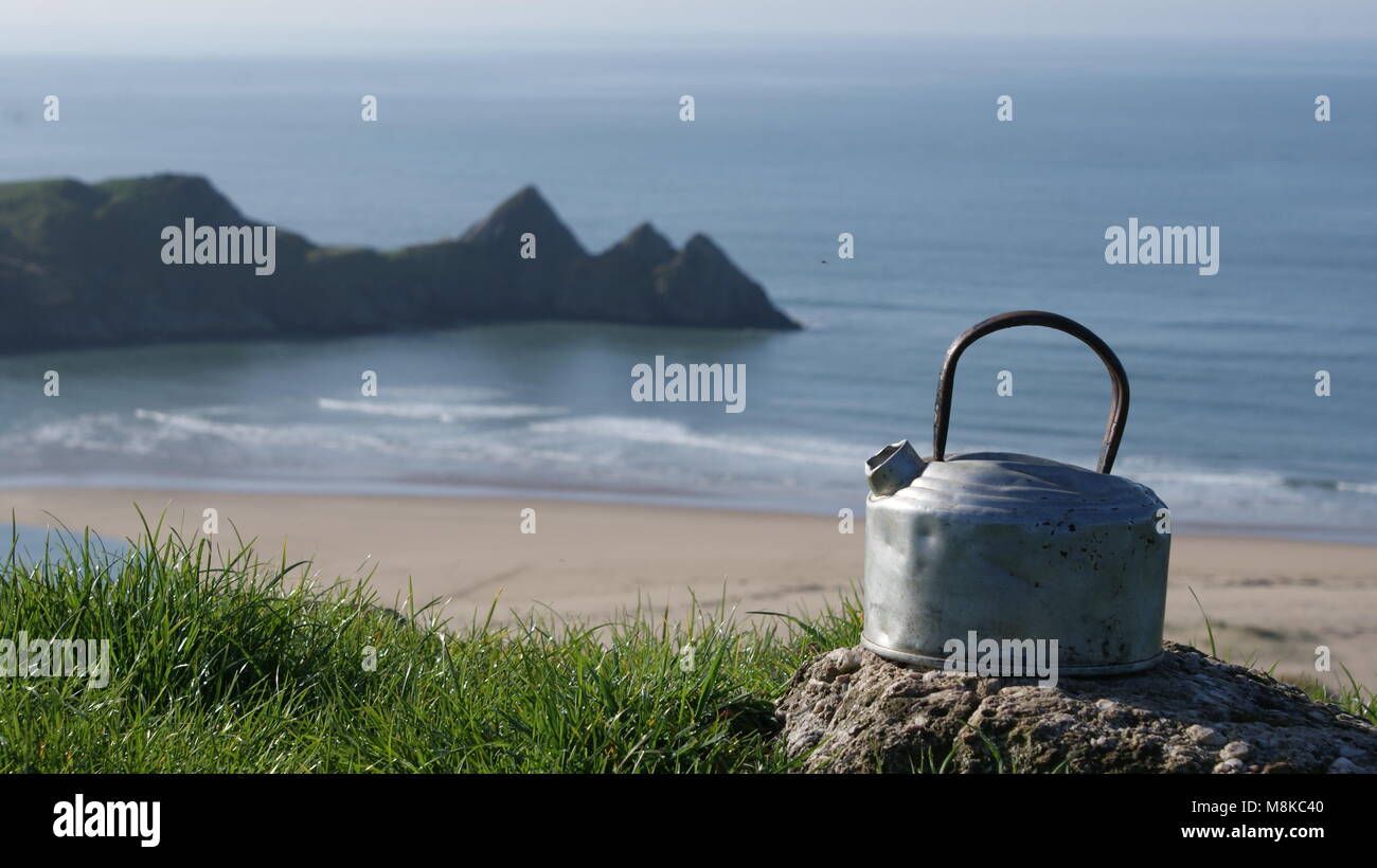 Meine alten camping Wasserkocher und der Blick auf die Three Cliffs Bay, Wales, UK. Stockfoto