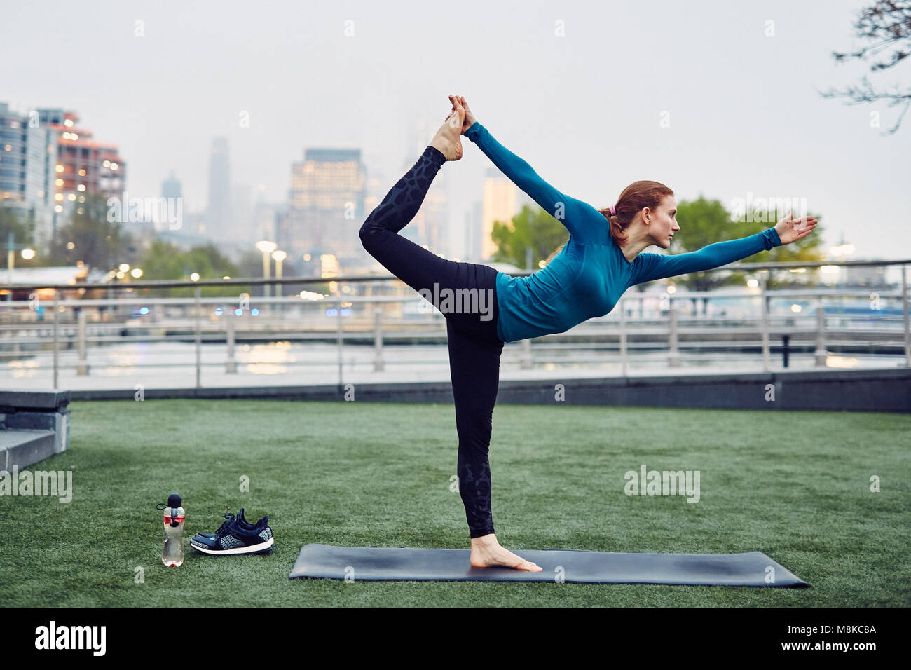 Kaukasische Frau übernimmt die Yoga in einem öffentlichen Park in New York City Stockfoto