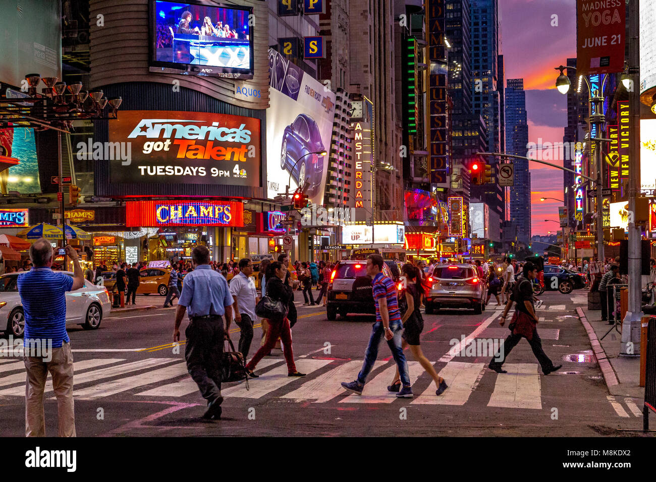 people on a pedestrian crossing near Times Square as thne sun sets over Manhattan ,New York Stockfoto