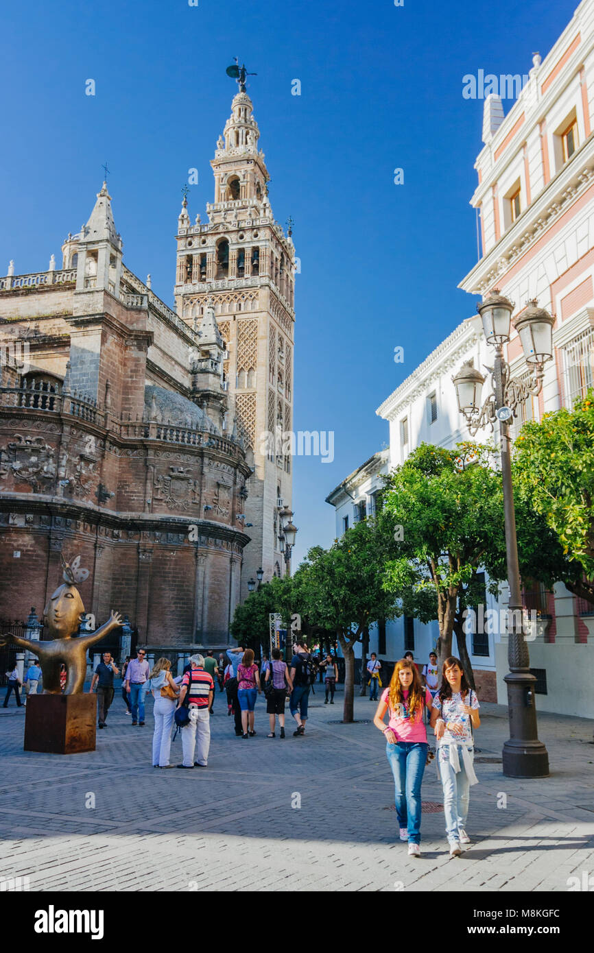 Sevilla, Andalusien, Spanien: Menschen gehen vorbei an der gotischen Kathedrale und Giralda Glockenturm an der Plaza del Triunfo Square. Stockfoto