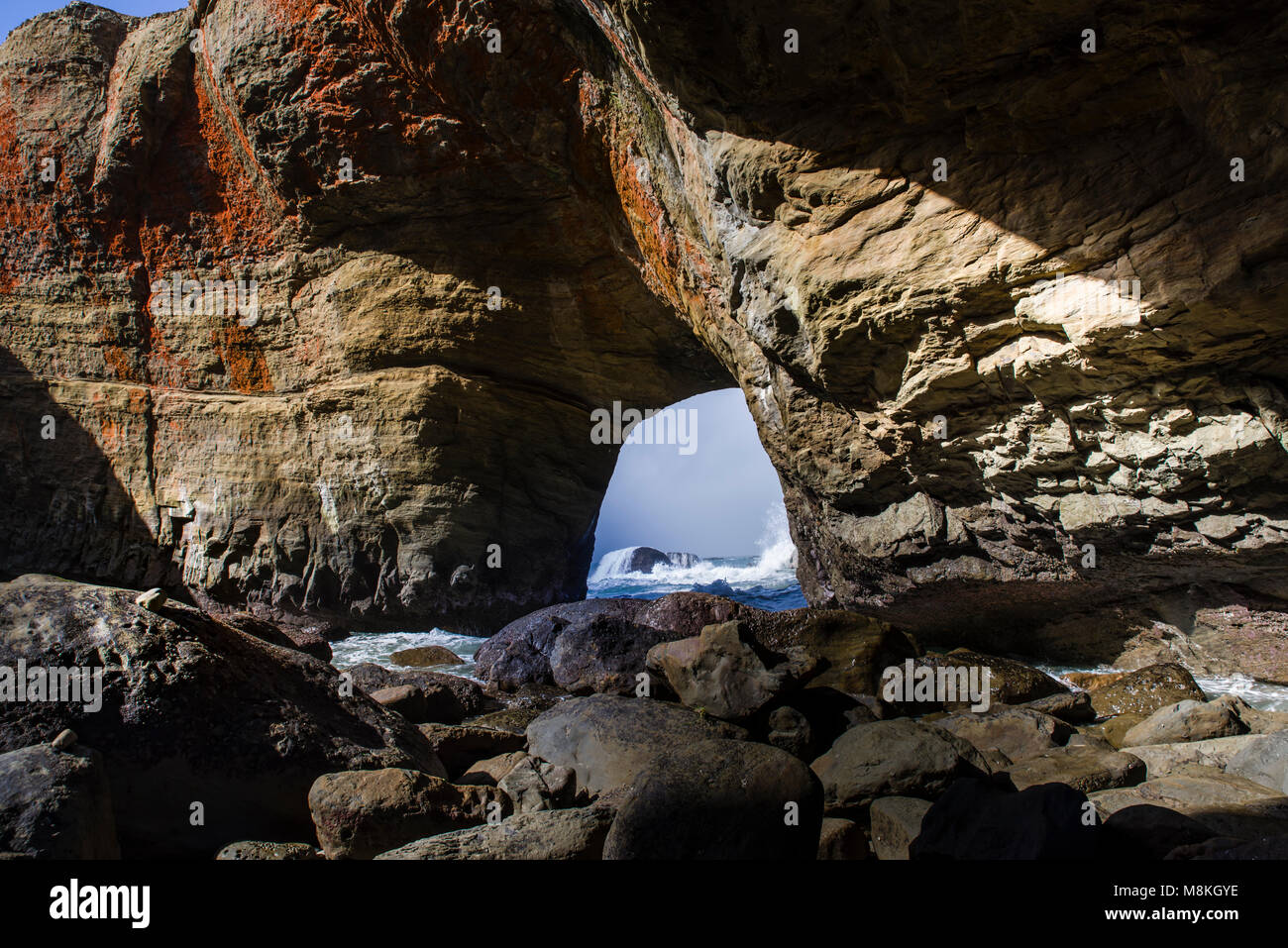 Devil's Punchbowl ist auf der Oregon Küste in der Nähe von Otter Rock. Dieses Bild ist aus dem Inneren der Felsen bei Ebbe mit den schönen Farben aus den Algen die Beschichtung der Felsen. Stockfoto