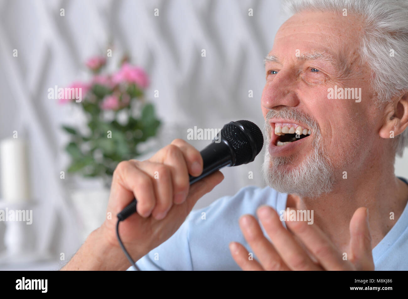 Aufgeregt, älterer Mann mit Mikrofon Stockfoto