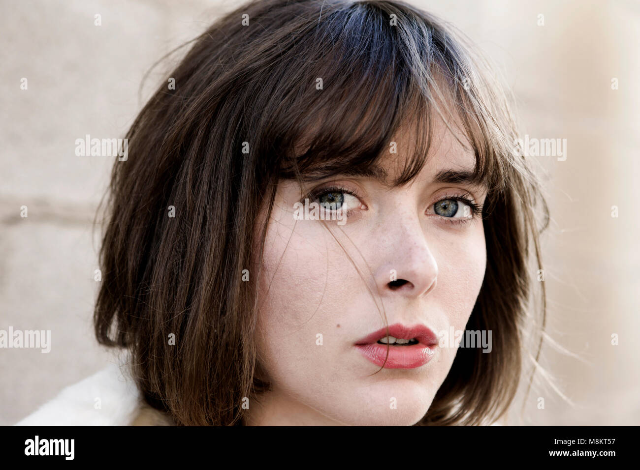 Porträt eines schönen, fairen dunkelhäutige Frau mit haselnussbraunen Augen, braunes Haar und roten Lippenstift, Stockfoto