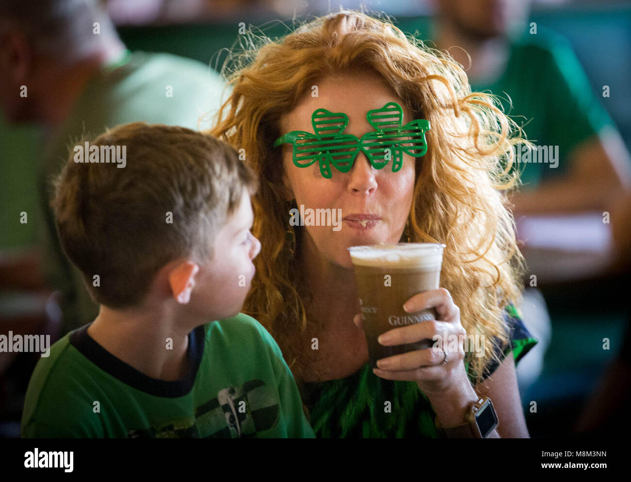 Palm Beach Gardens, Florida, USA. 18 Mär, 2018. Finn Tarpey, 7, Jupiter, Uhren, seine Mutter, Regan Tarpey, einen Schluck Guinness am St. Patrick's Day Feier bei Paddy Mac's in Palm Beach Gardens, Florida, am 17. März 2018 dauern. Credit: Allen Eyestone/der Palm Beach Post/ZUMA Draht/Alamy leben Nachrichten Stockfoto