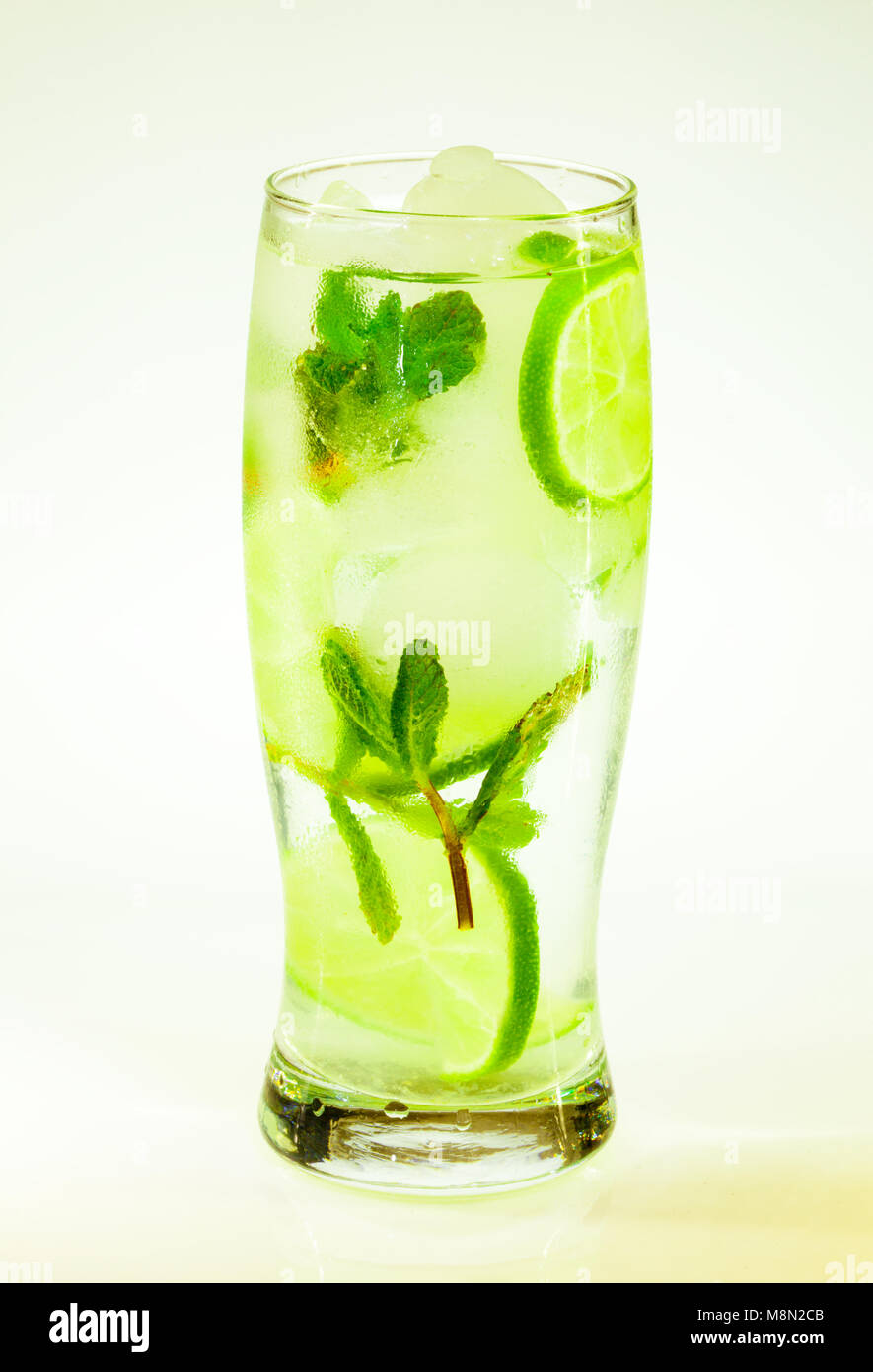 Sommer kalten Drink mojito Limette und Minze mit Eis und Soda mit Tropfen auf ein Glas auf weißem Hintergrund Stockfoto