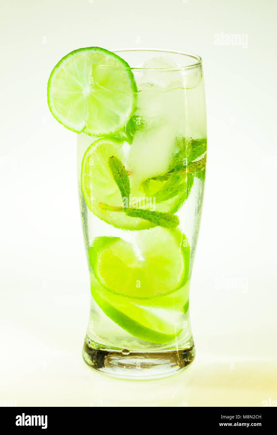 Sommer kalten Drink mojito Limette und Minze mit Eis und Soda mit Tropfen auf ein Glas auf weißem Hintergrund Stockfoto