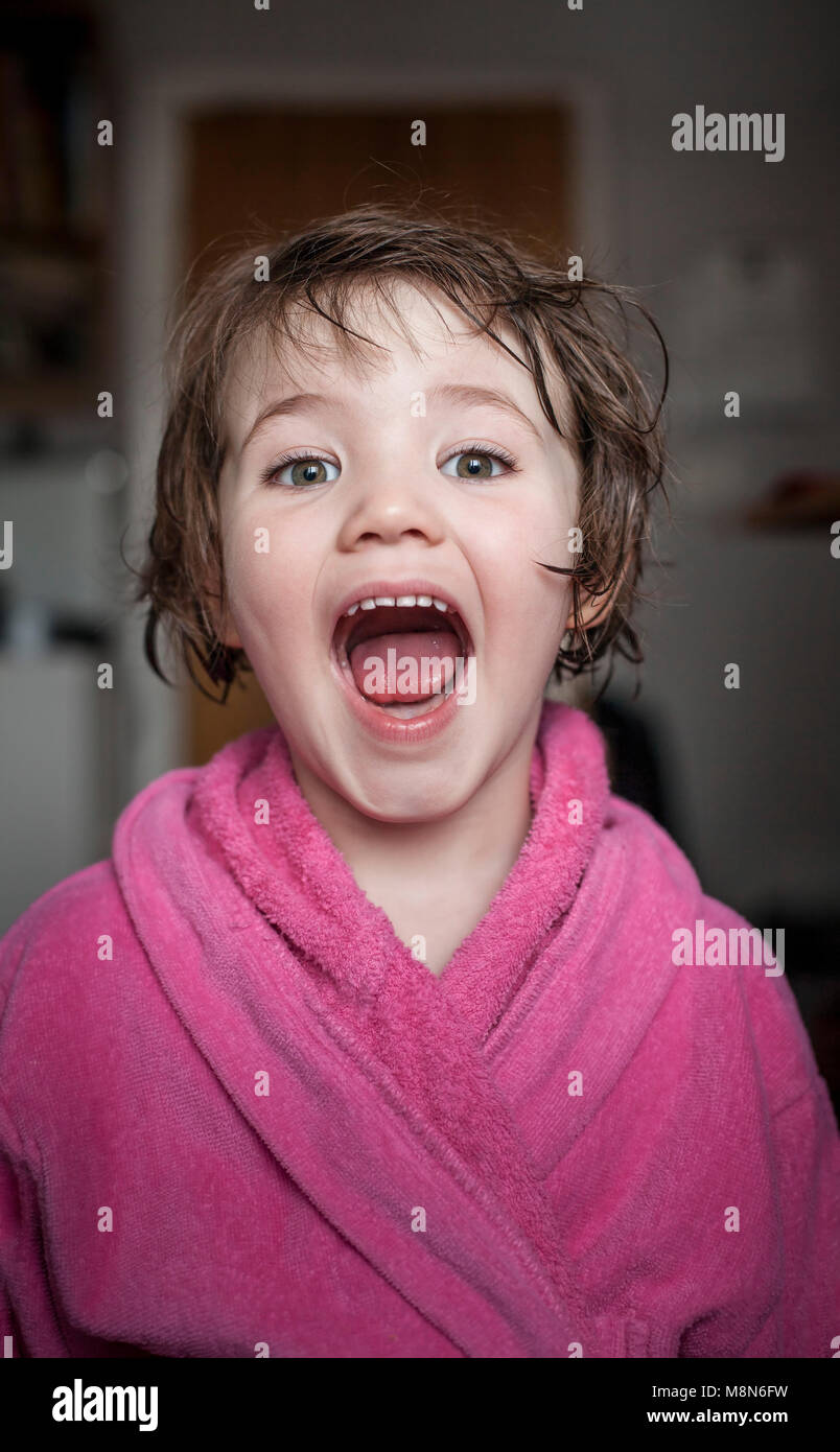 Junge Mädchen schreien mit offenen Mund in Bademantel mit kurzen nassen Haare zu Hause angezogen Stockfoto
