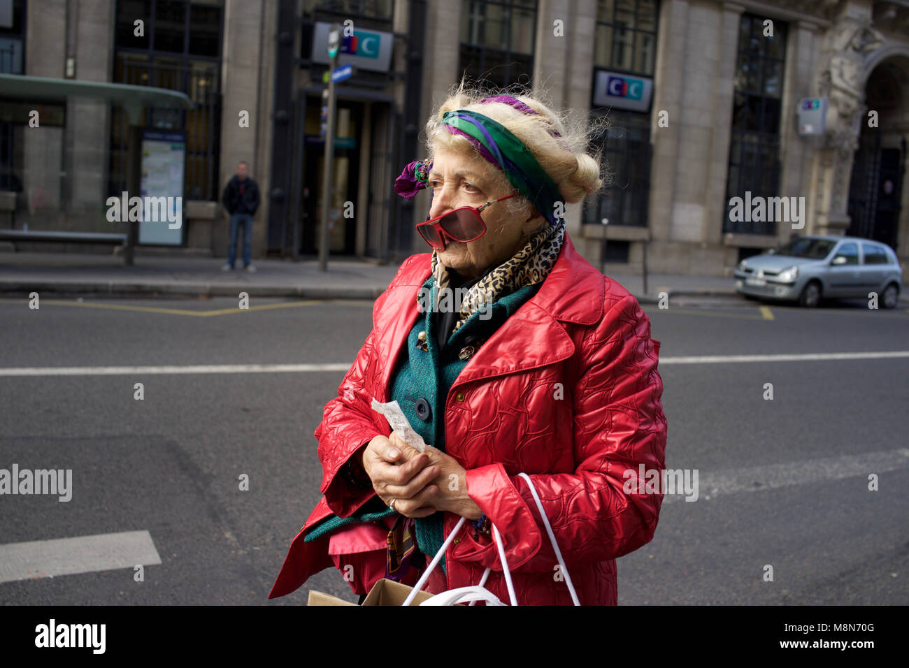 Exzentrische Frau Warten an der Bushaltestelle, tragen bunte, bunte, auffällige Kleidung, Paris Stockfoto