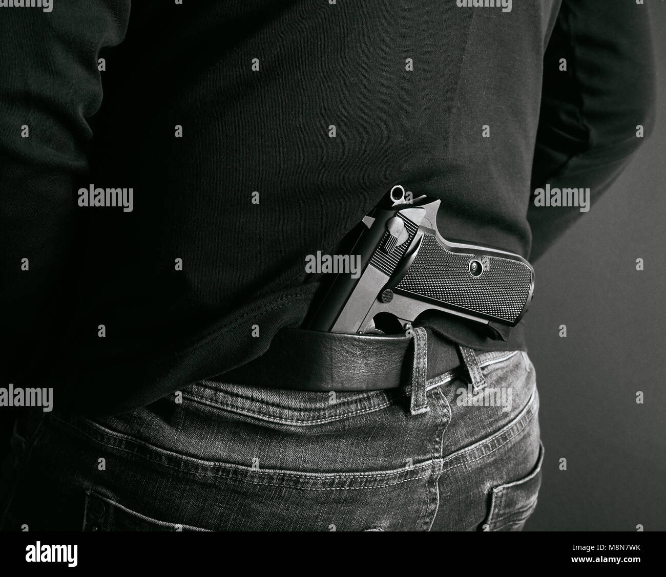 Gangster sein Gewehr hinter seinem Rücken. zurück und weiß Foto Stockfoto
