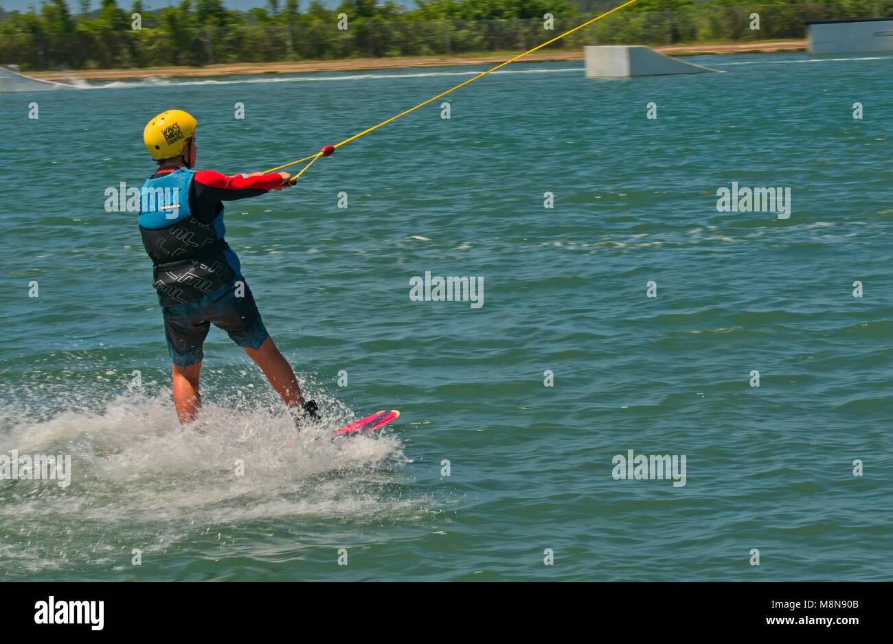Bli Bli, QLD, Australien - März 17, 2018: Junge männliche Teenager reiten ein Wakeboard an einem Kabel Water park Stockfoto