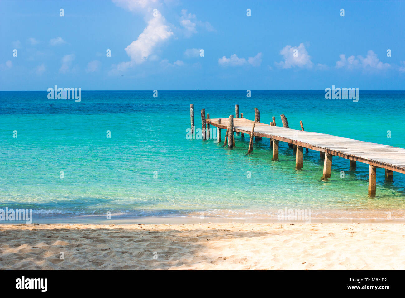 Holzbrücke am tropischen Strand und blauer Himmel Stockfoto