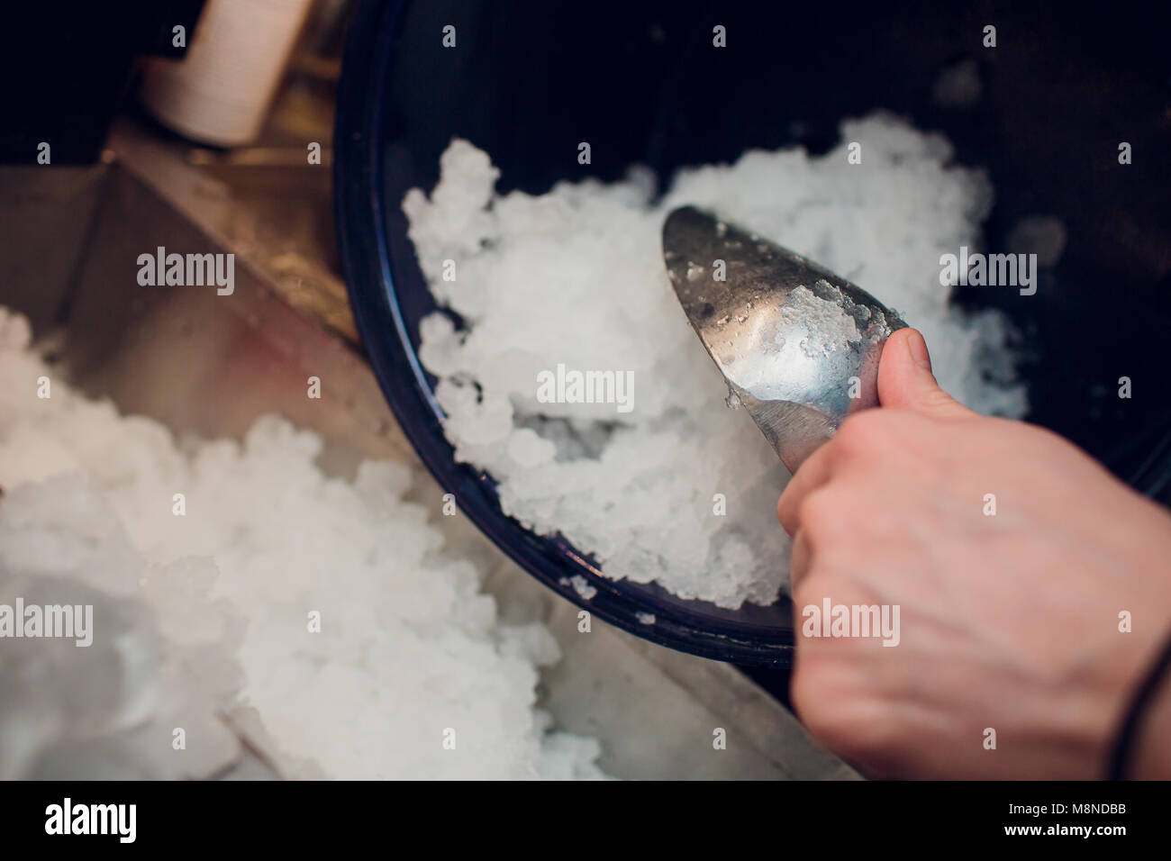 Silver Ice schaufeln in einem großen Eis gefüllten Eimer Stockfoto