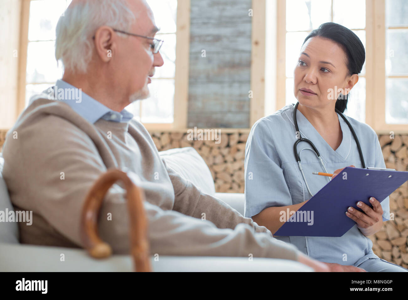 Besorgt Arzt merkte Senior mans Symptome Stockfoto