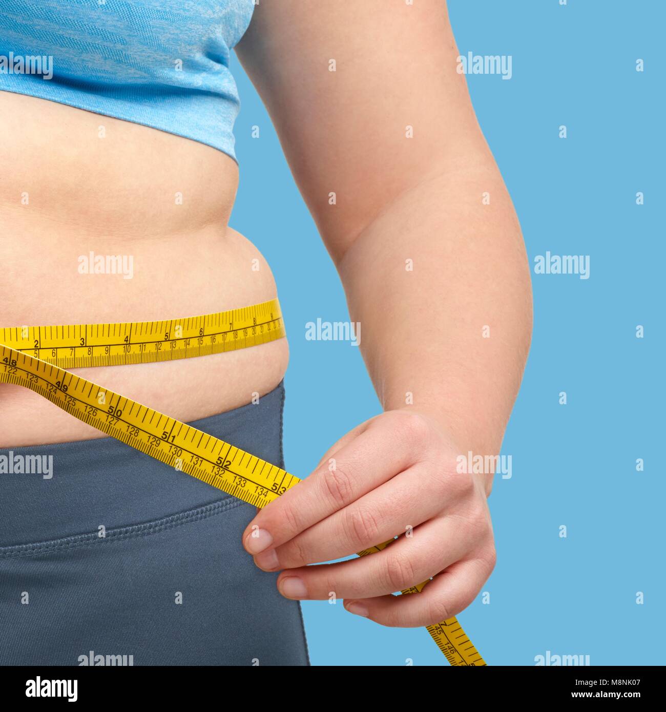 Übergewichtige Frau, die ihre Taille Messen mit dem Maßband. Stockfoto