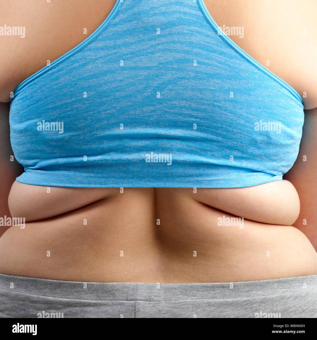 Übergewichtige Frau in Blau 7/8 oben, Ansicht von hinten. Stockfoto
