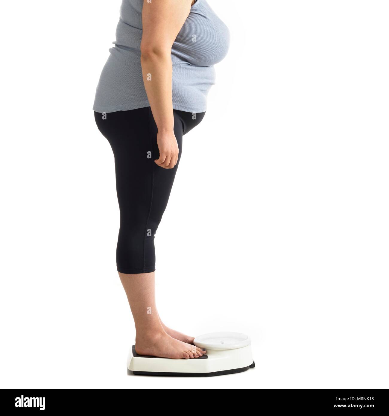 Übergewichtige Frau, die auf eine Waage. Stockfoto