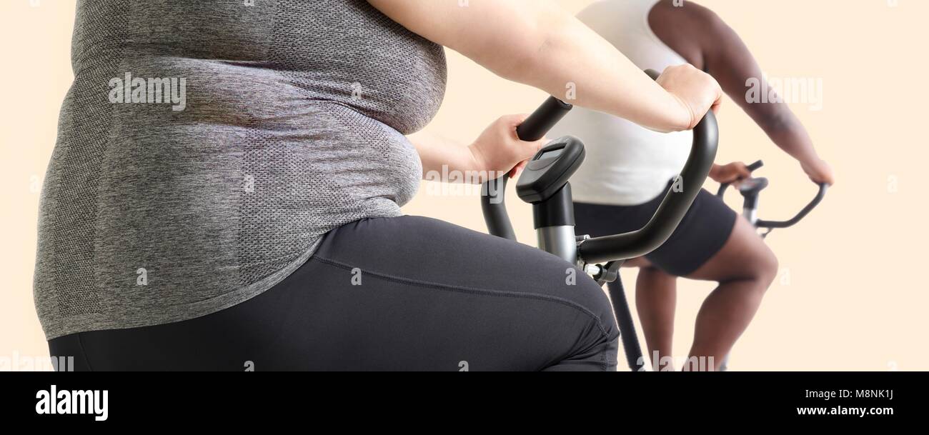 Übergewichtige Frau und Mann auf Heimtrainern. Stockfoto
