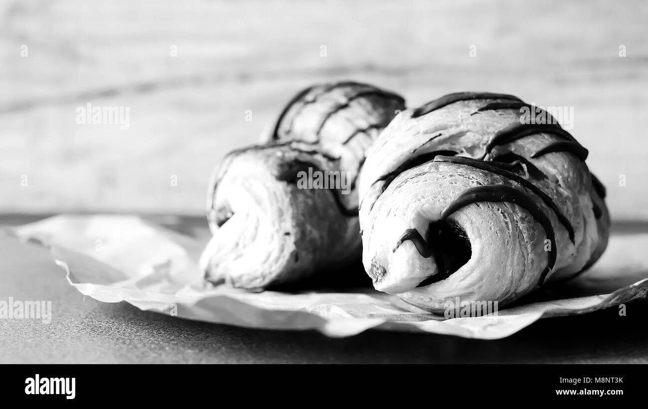 Croissants mit Schokolade auf dem Tisch schwarz-weiss Poster. Stockfoto